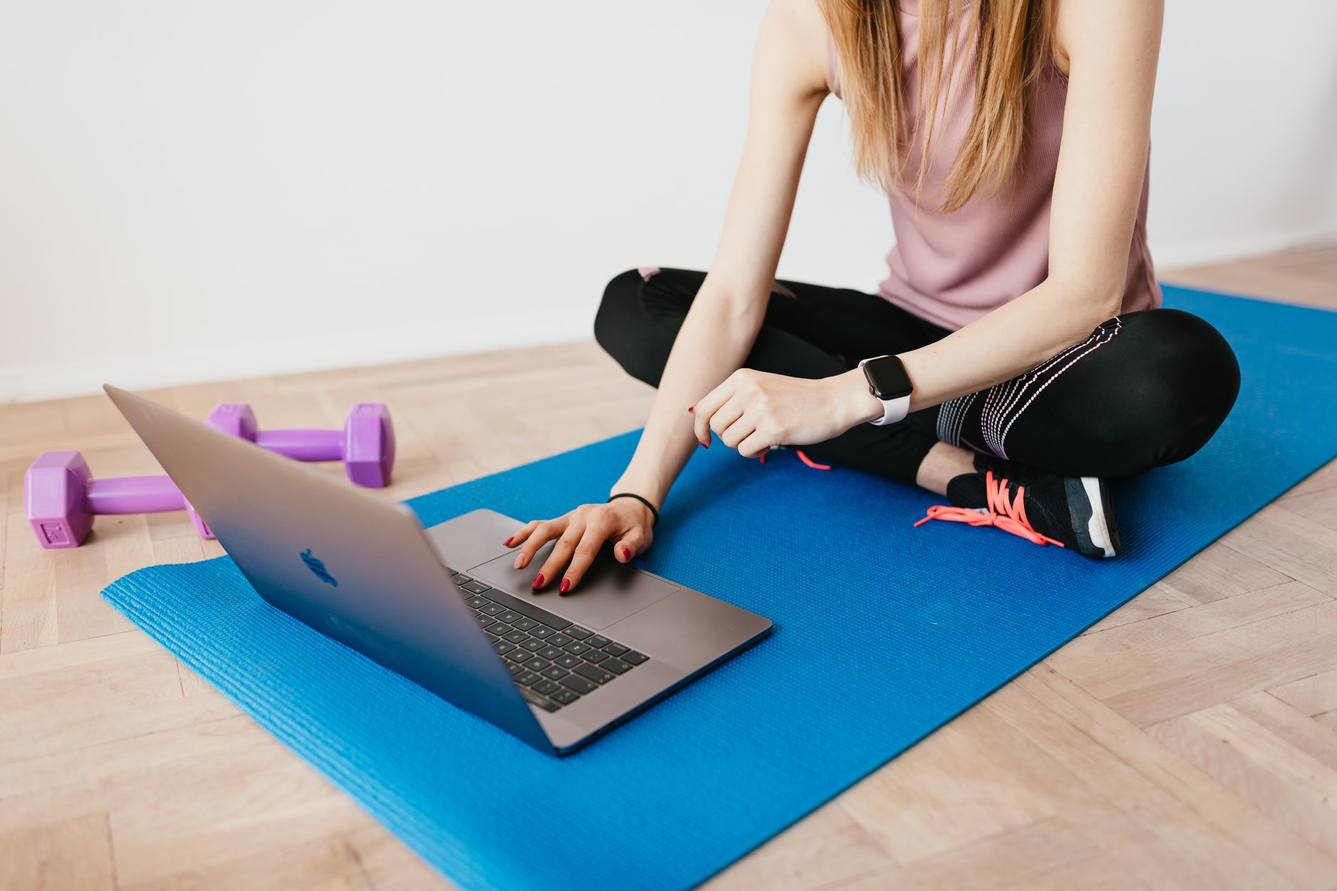 crop woman in activewear browsing laptop